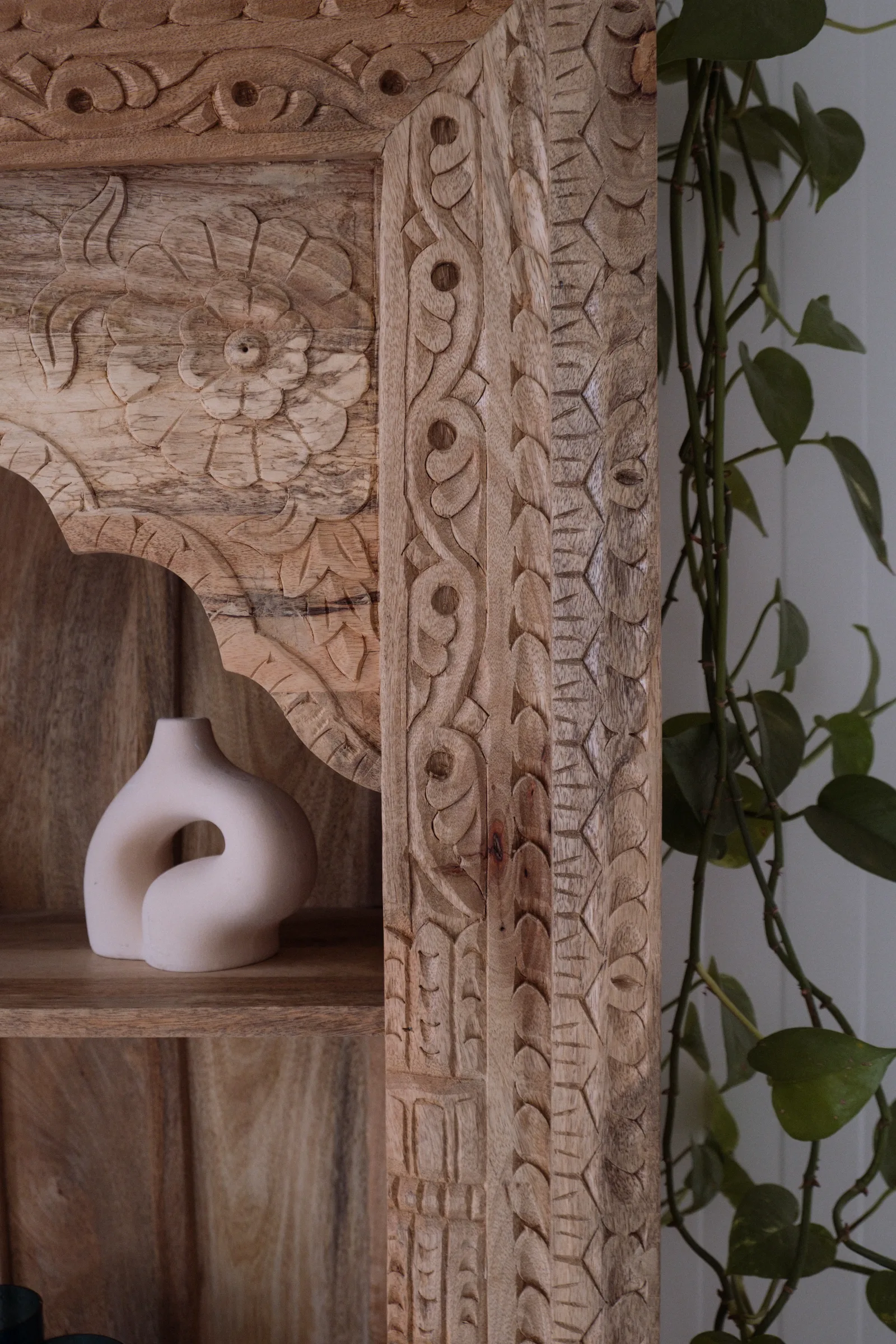 A wood carving with a vase