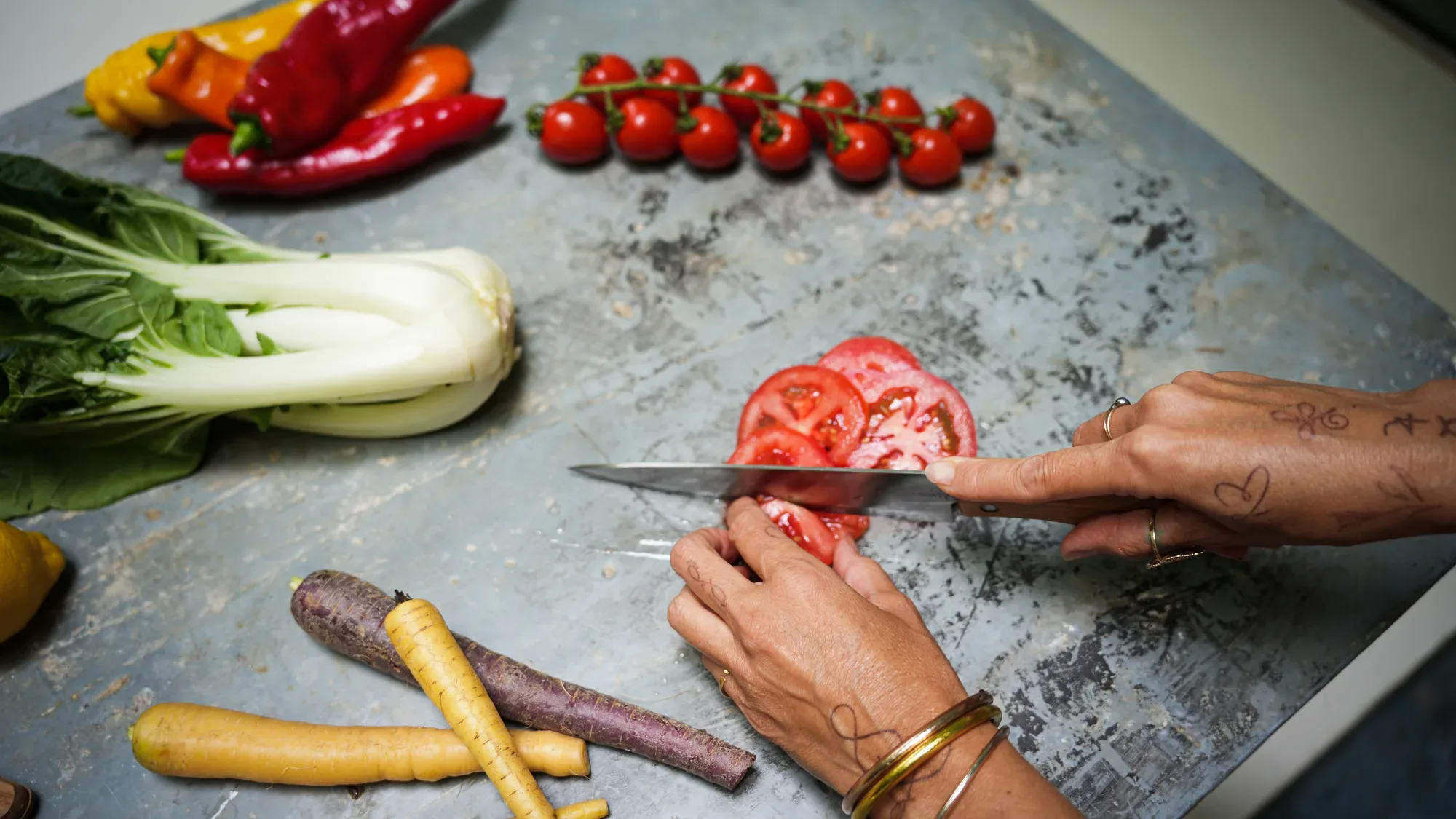 Eva cutting vegetables on a stone worktop