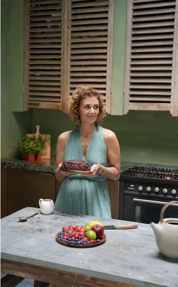 Eva Reyes in her kitchen, holding a plate of food